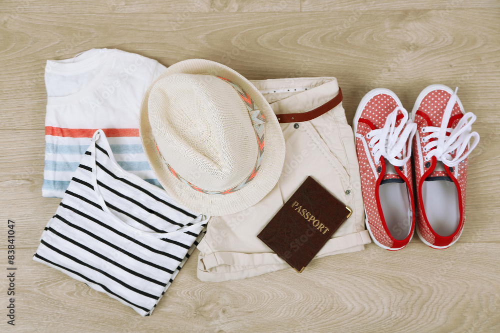 Summer vacation clothes, shoes and hat on wooden background