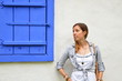 © creativefamily - Young girl posing by the blue window shutters