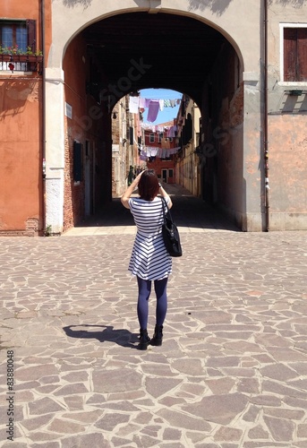 Juliste ragazza fa foto a bel paesaggo urbano con panni stesi