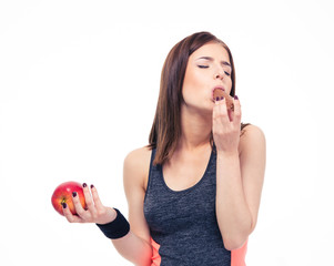 Sticker - Beautiful sports woman holding apple and eating chocolate