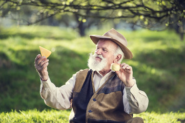 Senior farmer with organic cheese outside in nature