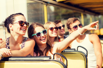 group of smiling friends traveling by tour bus