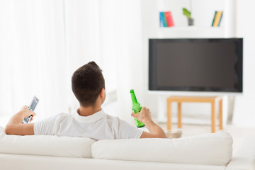 Wall Mural - man watching tv and drinking beer at home