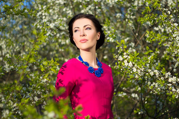 Wall Mural - portrait of young beautiful woman in garden with blooming trees