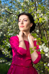 Wall Mural - portrait of young woman posing in blooming garden