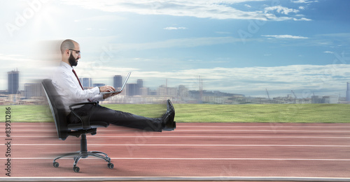 Fotomural Fast business - businessman sitting with laptop runs on track