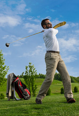 Business man swinging a golf club