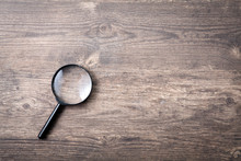 Magnifying Glass On Wooden Table, Search And Discover Symbol