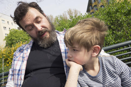 Photo Vater und Sohn auf Parkbank in Wohnsiedlung. Berlin.