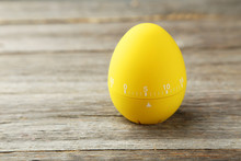 Yellow Egg Timer On Grey Wooden Background