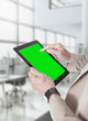 Mani con tablet a sfondo verde