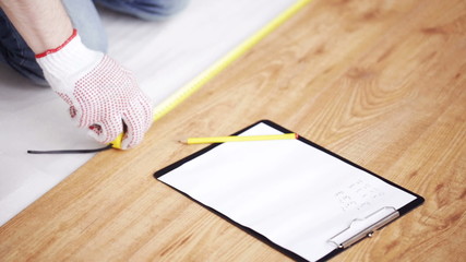 Wall Mural - close up of man measuring flooring and writing