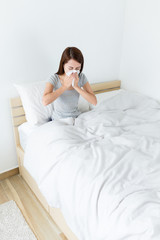 Wall Mural - Asian woman feeling sick and sneeze at living room