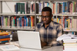 © Jale Ibrak - Happy African Male Student With Laptop In Library