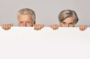 Old age couple holding blank banner 