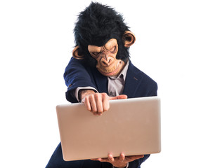 Wall Mural - Frustrated monkey man holding a laptop