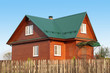 Wooden house under green metal roof
