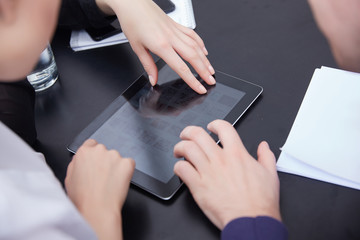 hand a group of businessmen on a table with a tablet, mobile pho