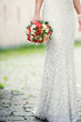 Bride is holding a bouquet of roses
