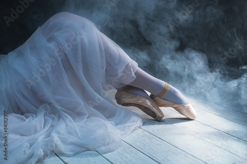Fotografie, Tablou The feet of a sitting ballerina in smoke. Dancing legs.