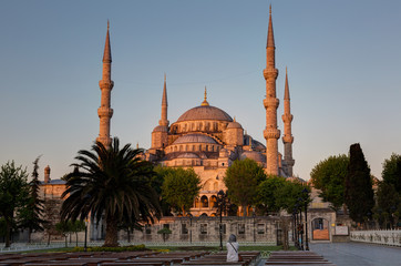 Wall Mural - girl sitting on a bench looks at the Blue mosque 