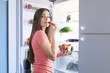 © Tommaso Lizzul - young beautiful woman eating strawberries from the fridge