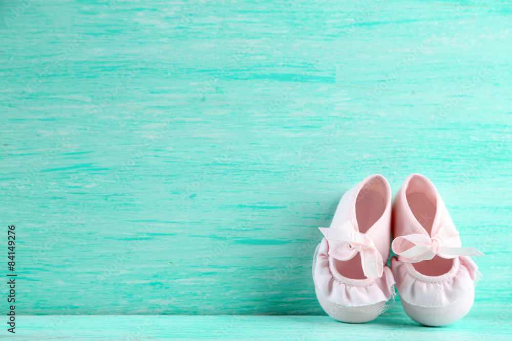Pink toddler shoes on wooden background