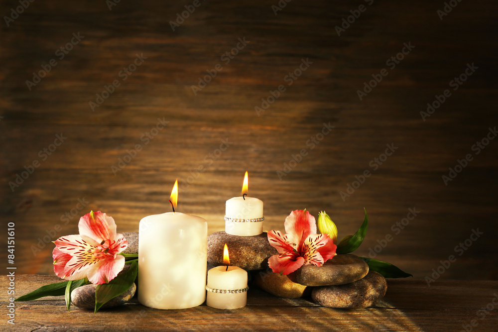 Beautiful composition with candles and spa stones on wooden background