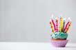 Delicious birthday cupcake on light background