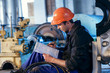 © kuznetsov_konsta - Worker on industry studying manual instructions repair turbine.