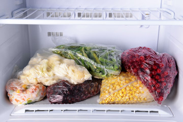 Canvas Print - Frozen berries and vegetables in bags in freezer close up