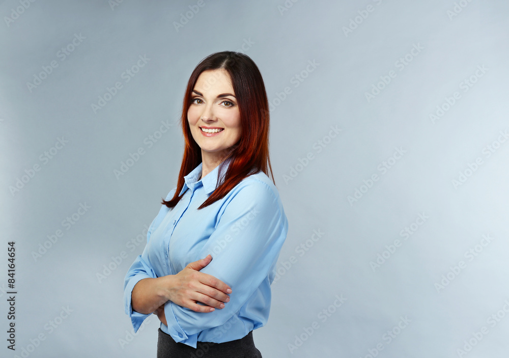 Beautiful middle aged businesswoman on grey background