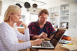 © Monkey Business - Stressed couple sitting in their kitchen using computers