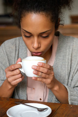 Wall Mural - Young african american woman drinking cup of coffee