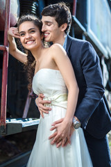 Wall Mural - Portrait of happy wedding couple near the old steam locomotive