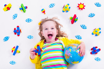 Wall Mural - Little girl playing with wooden airplane