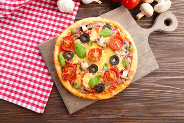 Wall Mural - Tasty pizza with vegetables and basil on table close up