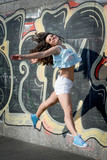 Fototapeta  - Happy Young Woman Jumping Outdoors. Urban style.