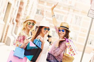 Wall Mural - Group of happy friends shopping in the city