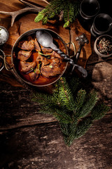 venison goulash stew in pot with serving spoon