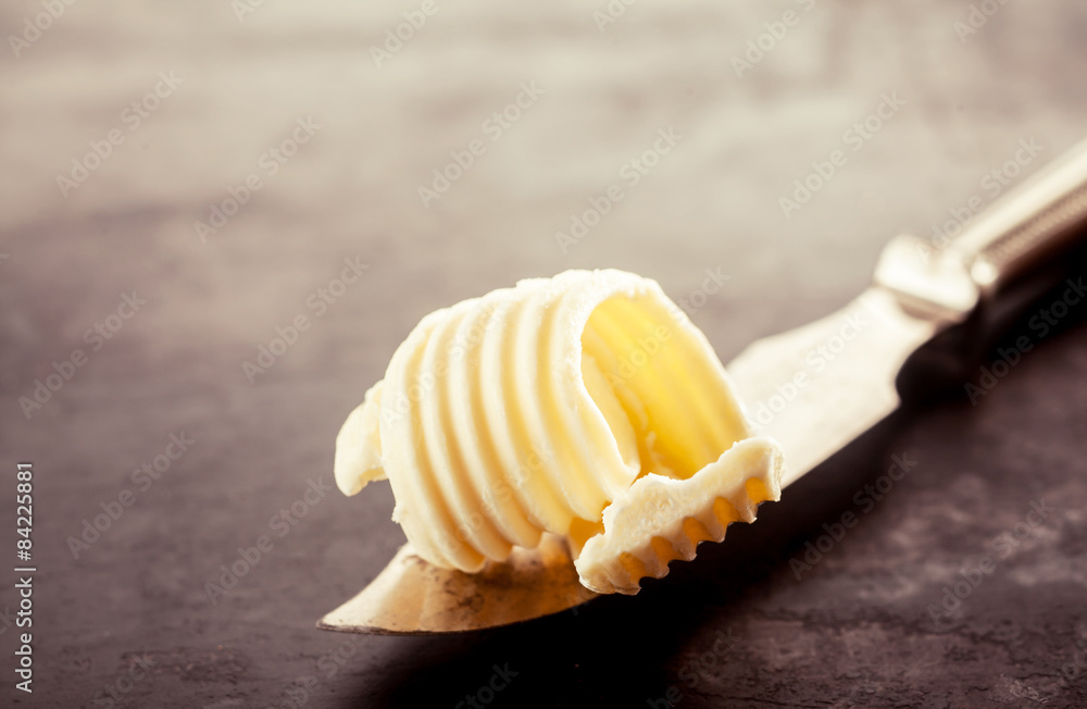 Butter on a Knife on Top of a Wooden Table - obrazy, fototapety, plakaty 