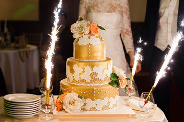 Beautiful golden wedding cake with flowers 