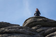 Tourist climbs up the granite slopes of Haytor Rocks