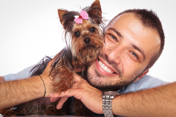 man is holding his pet yorkshire terrier puppy dog