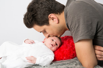 Father kissing his new born baby  forehead