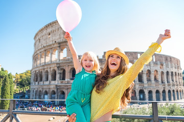 Wall Mural - Cheering mother and daughter with pink balloon at Colosseum