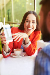 Wall Mural - woman showing her cellphone to man