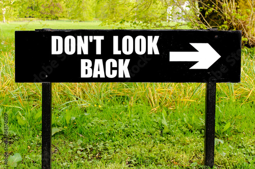 Foto DO NOT LOOK BACK written on directional black metal sign