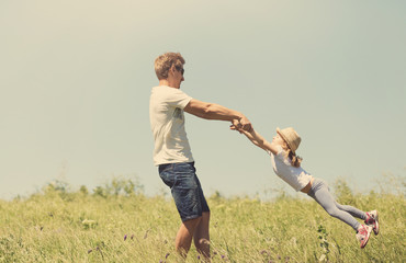 Father and daughter spinnig outdoor