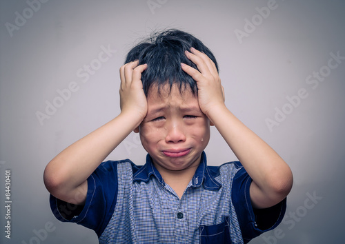 Fotomural Asian boy crying over dark background